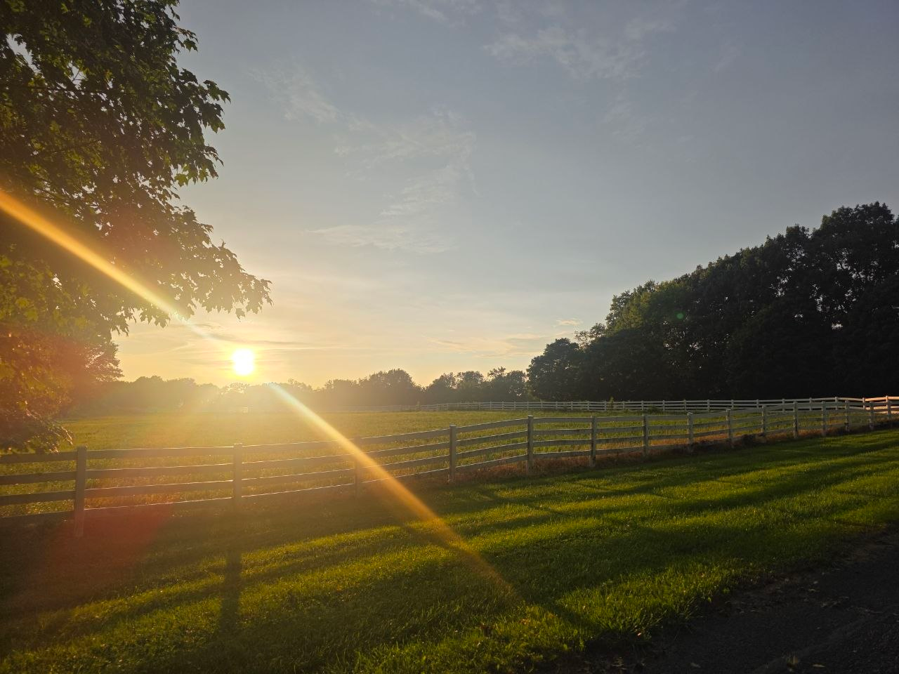 Sunrise over the pastures and white fencing at Hartford Lake Resort